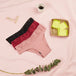 Pack Sexy baby : ensemble de 3 culottes menstruelles Brazilian Light avec paniers de protège-lingeries Nana Voile Si Discret sur fond rose.